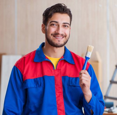 Yooung marangoz boyayla uğraşıyor.