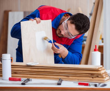 Yooung marangoz boyayla uğraşıyor.