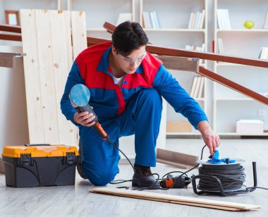 Genç marangoz ahşap kalaslarla çalışıyor.