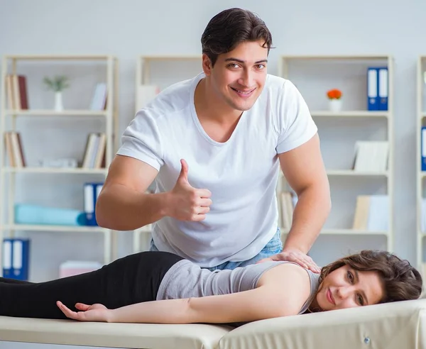 Jonge arts chiropractor masseren vrouwelijke patiënt vrouw — Stockfoto