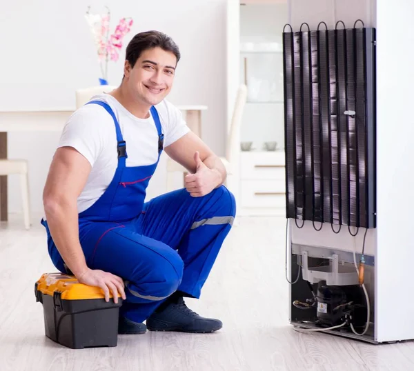 Repairman contractor repairing fridge in DIY concept