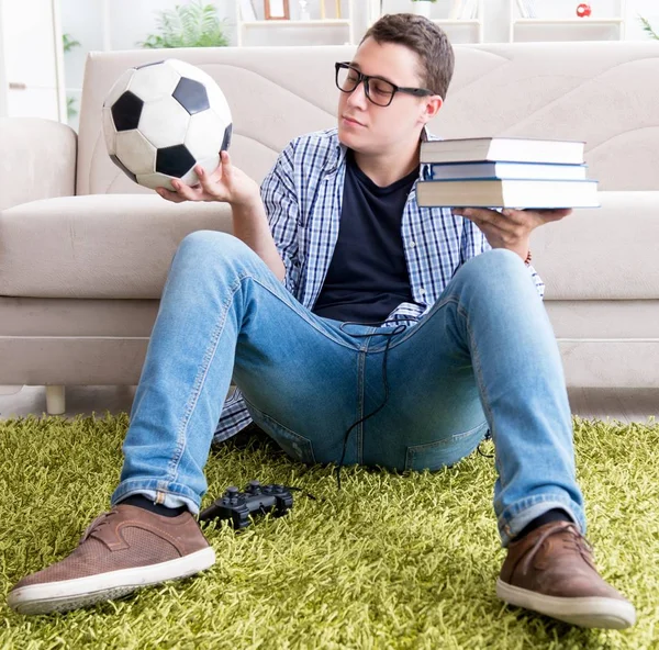 Joven estudiante tratando de equilibrar estudiar y jugar al fútbol — Foto de Stock