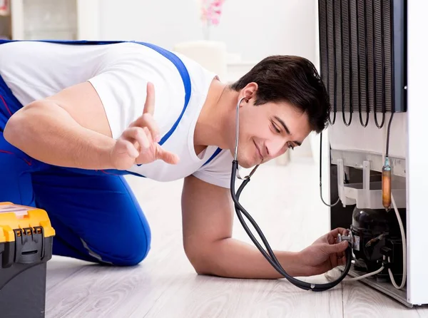 Repairman contractor repairing fridge in DIY concept