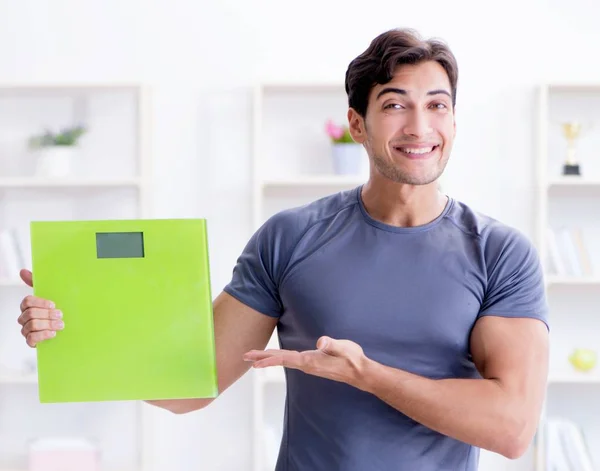 Hombre con escalas en concepto deportivo y de salud — Foto de Stock