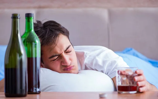 Hombre alcohólico bebiendo en la cama pasando por romper la depresión —  Fotos de Stock