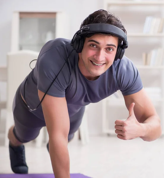 Hombre haciendo deportes en casa y escuchando música —  Fotos de Stock