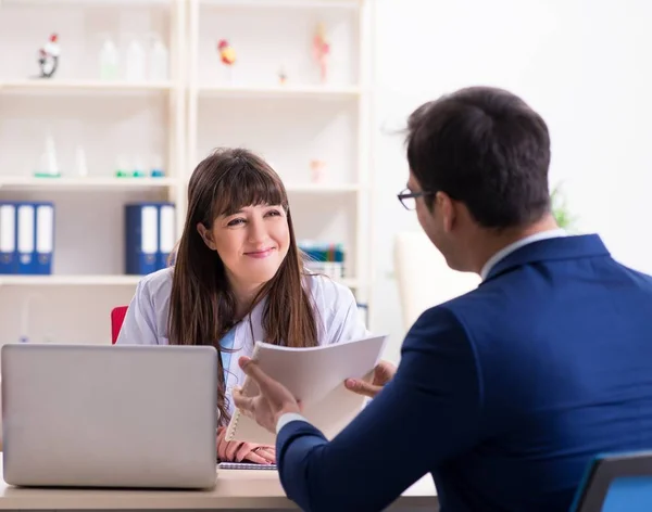 Forretningsmann diskuterer helseproblemer med lege – stockfoto