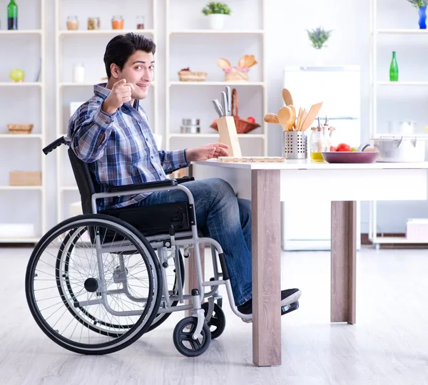 Engelli genç koca mutfakta çalışıyor.