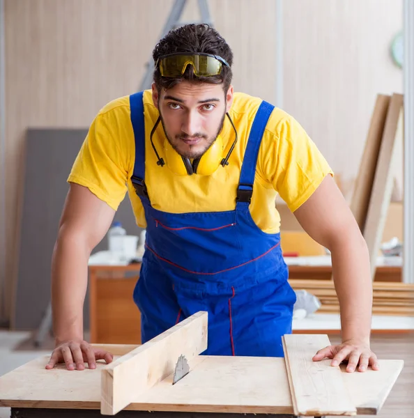 Genç bir marangoz dairesel testere ile çalışıyor. — Stok fotoğraf