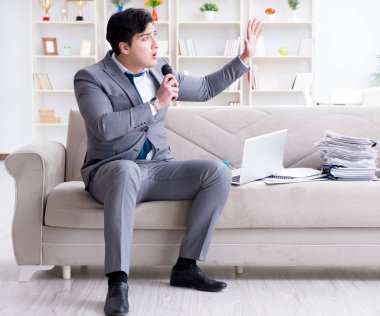 Üzgün işadamı ofiste şarkı söylüyor.