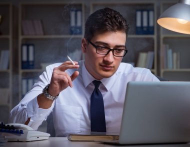 Stres altındaki iş adamı ofiste sigara içiyor