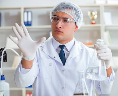 Genç araştırmacı bilim adamı bir su testi kirliliği araştırması yapıyor.