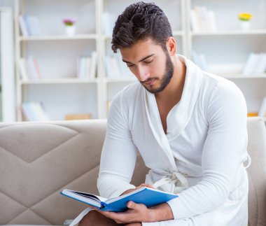 Öğrenci işadamı genç adam bir kitap okuyor.