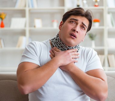 Genç adam boğaz ağrısı çekiyor.