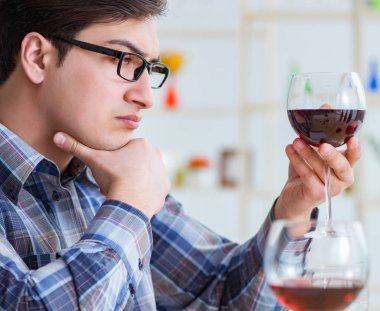 Profesyonel şarap garsonu kırmızı şarap tadıyor.