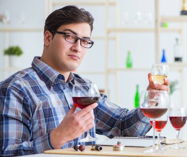 Profesyonel şarap garsonu kırmızı şarap tadıyor.
