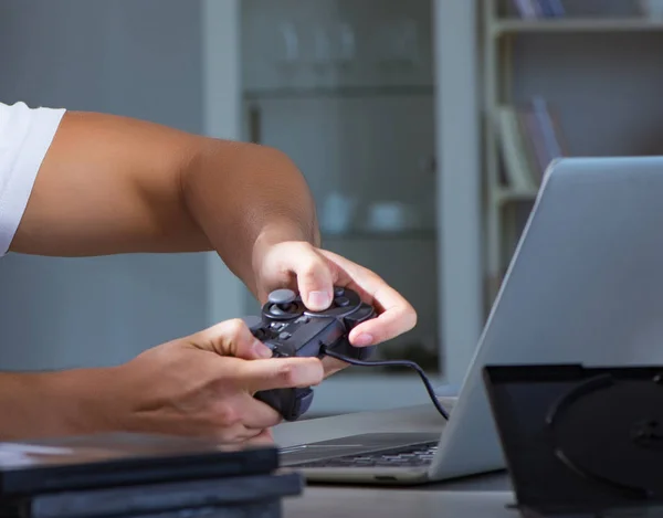 Jovem jogando jogos longas horas atrasado no escritório — Fotografia de Stock