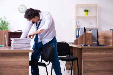 Genç bir erkek işçi aşırı işten memnun değil.