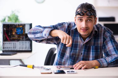 Genç yakışıklı teknisyen cep telefonu tamir