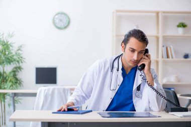 Klinikte çalışan genç erkek doktor.