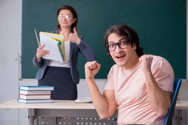 Velha professora e estudante do sexo masculino na sala de aula — Fotografia de Stock