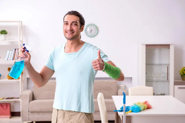 Young injured man cleaning the house — Stock Photo, Image