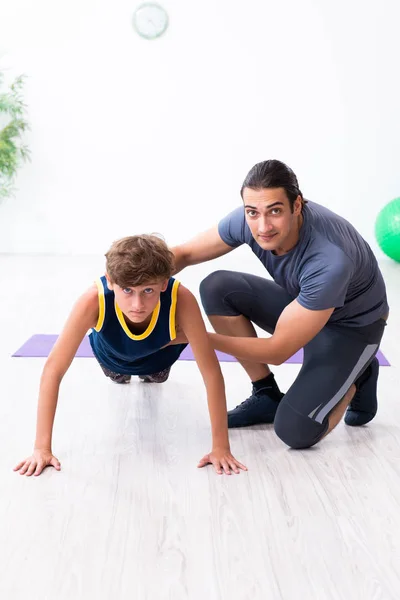 Jovem pai e seu filho fazendo exercícios — Fotografia de Stock