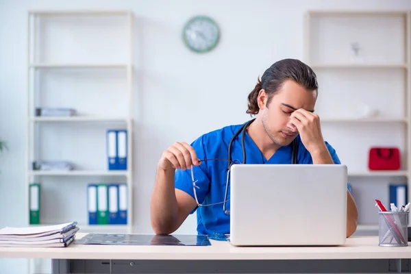 Ung manlig läkare som arbetar på kliniken — Stockfoto