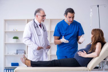 İki doktor genç kadını muayene ediyor.