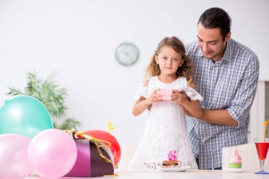 Baba kızıyla doğum gününü kutluyor.