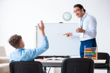 Genç baba oğlunun sınava hazırlanmasına yardım ediyor.