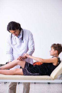 Erkek basketbolcu, genç doktor travmatoloğu ziyaret ediyor.