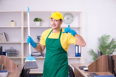 Genç müteahhit ofisi temizliyor.