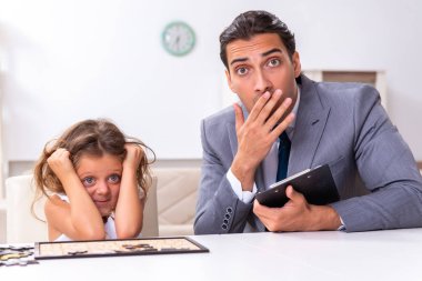 Çocuk psikoloğu küçük bir kıza bakıyor