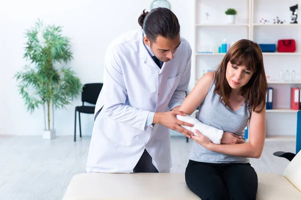 Giovane donna in visita medico traumatologo maschile — Foto Stock