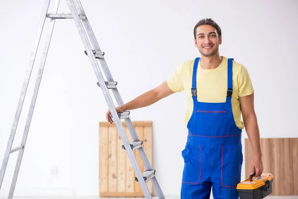 Jovem empreiteiro do sexo masculino trabalhando dentro de casa — Fotografia de Stock