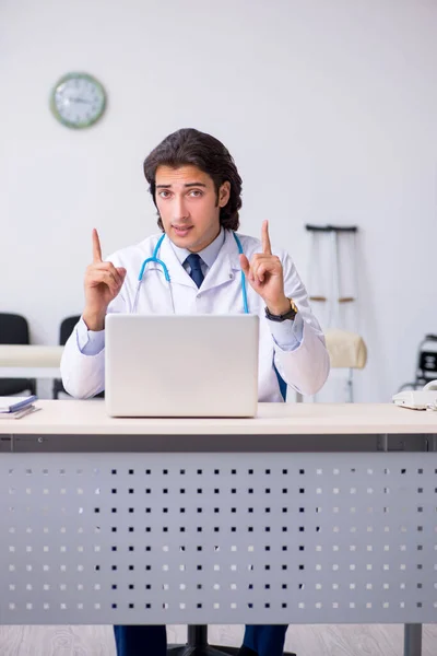 Mladý pohledný lékař pracující na klinice — Stock fotografie