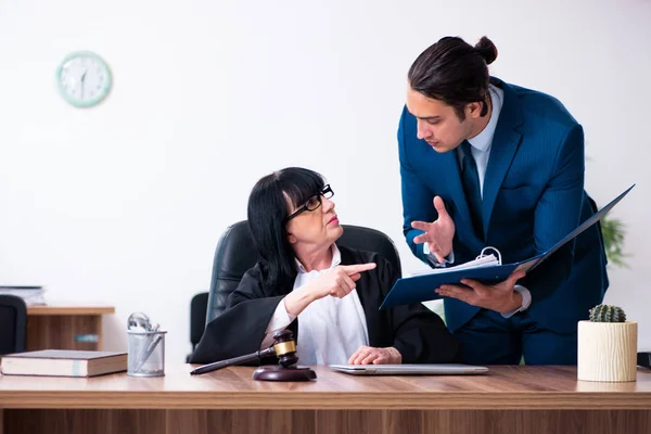 Jeune stagiaire demandant conseil à un juge principal — Photo