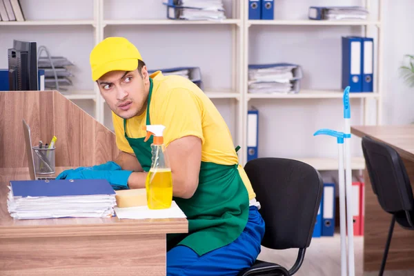 Jovem empreiteiro limpando o escritório — Fotografia de Stock