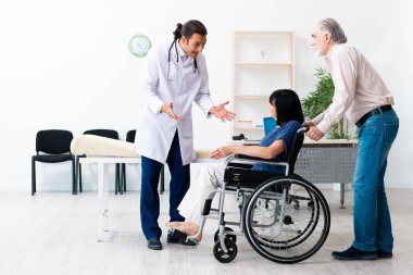 Yaşlı çift genç erkek doktoru ziyaret ediyor.