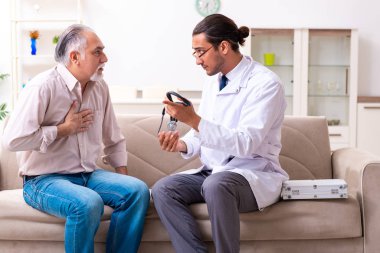 Genç erkek doktor eski hastayı ziyaret ediyor.