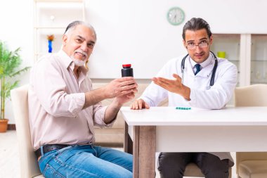 Genç erkek doktor eski hastayı ziyaret ediyor.