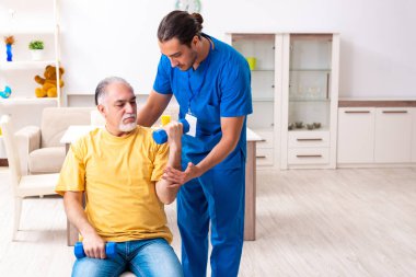 Genç erkek doktor eski hastayı ziyaret ediyor.