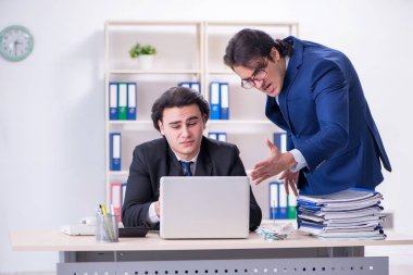 Patron ve erkek asistanı ofiste çalışıyor.