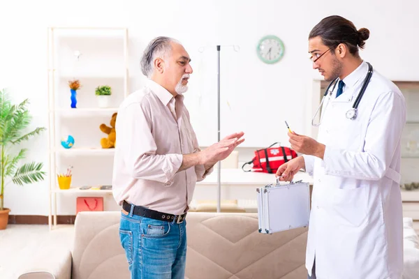 Genç erkek doktor eski hastayı ziyaret ediyor. — Stok fotoğraf