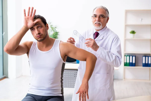 Junge männliche Patientin besucht erfahrenen Arzt — Stockfoto