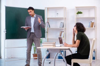 Genç öğretmen ve öğrenci sınıfta.