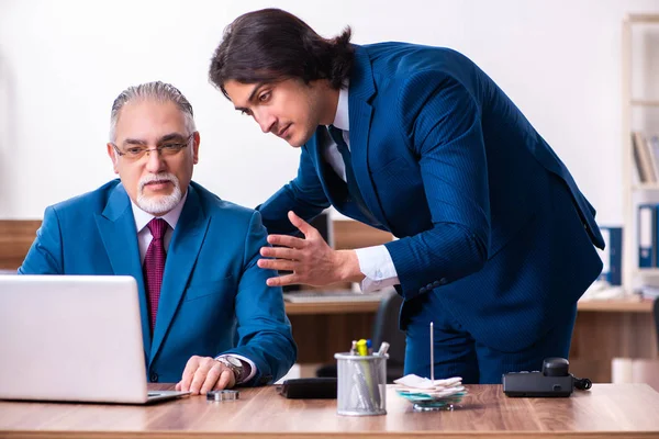 Employés jeunes et vieux travaillant ensemble au bureau — Photo