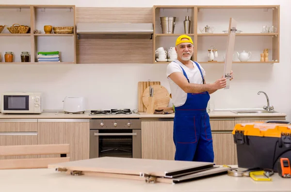 Verouderde aannemer reparateur werken in de keuken — Stockfoto