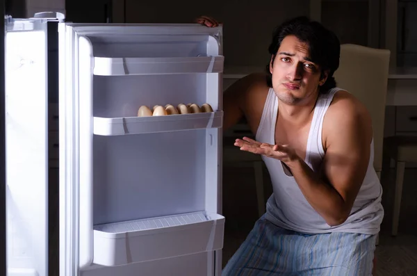 Man breaking diet at night near fridge — Stock Photo, Image